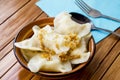 Delicious homemade dumplings in a plate on a wooden table.