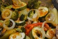 Potato wedges with healthy vegetables, zucchini, rings of onions, pieces of broccoli, slices of red bell pepper.