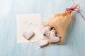 Delicious homemade heart shaped cookies sprinkled with powdered sugar in craft bag for valentine`s day gift with note