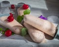 Homemade ice cream of fruit and cream on decorative sticks is on a light wooden background. The composition is decorated with Royalty Free Stock Photo