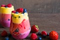 Delicious homemade layered fruit and berry smoothie dessert in glasses