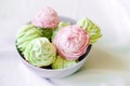 Delicious homemade mint and raspberry marshmallow in a gray bowl on the table.