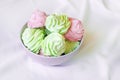 Delicious homemade mint and raspberry marshmallow in a gray bowl on the table.