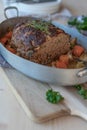 Baked meatloaf with root vegetables in a roasting pan