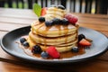 Delicious homemade pancakes with syrup and fresh berries served on a plate - perfect breakfast dish Royalty Free Stock Photo