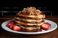 Delicious homemade pancakes in syrup with nuts and fresh strawberries on a white plate Royalty Free Stock Photo