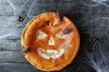 Delicious homemade pie for halloween on black wooden table with spiders web and cockroaches