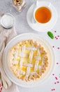 Delicious homemade puff pastry pie or cake with cream cheese filling and cherry on a white plate on a light stone background. Royalty Free Stock Photo