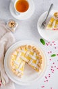 Delicious homemade puff pastry pie or cake with cream cheese filling and cherry on a white plate on a light stone background. Royalty Free Stock Photo