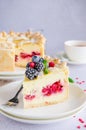 Delicious homemade puff pastry pie or cake with cream cheese filling and cherry on a white plate on a light stone background. Royalty Free Stock Photo