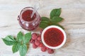 Delicious homemade raspberry jam im jar and white bowl. Fresh berries and leaves Royalty Free Stock Photo