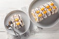 Delicious homemade Swedish dessert Budapest roll cake filled with whipped cream and mandarins close-up in a plate on the table. Royalty Free Stock Photo