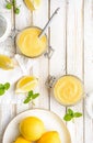 Homemade tangy lemon curd decorated with fresh fruit in a glass jars on rustic wooden background Royalty Free Stock Photo