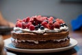 Delicious homemade vegan cake topped and decorated with cream and berry fruits