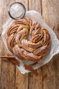 Delicious Homemade Wreath Kringle with sugar and cinnamon closeup on the paper. Vertical top view