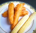 Delicious hot Baby corn baji with fresh baby corn placed in plate with black backgrounds and packed with vital antioxidants and