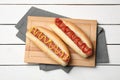 Delicious hot dogs with mustard and ketchup on white wooden table, top view Royalty Free Stock Photo