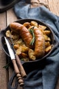 Delicious hot hearty food: fried potatoes with sausages on the grill in a cast iron pan.