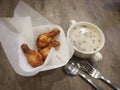 Delicious hot mushroom soup and chiken wing on wooden table at Pizza Hutt Restaurant.
