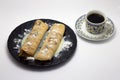 Delicious hot pancakes on a black plate with a cup of coffee isolated on white background Royalty Free Stock Photo