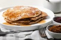 Delicious hot pancakes with maple syrup. Traditional delicious dessert or sweet breakfast on a white plate on a light table. Forks Royalty Free Stock Photo