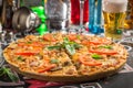 Delicious hot pizza with ham and mushroom and glass of cold beer on bar background Royalty Free Stock Photo