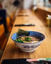 Delicious hot warming japanese ramen noodles soup in a traditional blue bowl on the table, upright Royalty Free Stock Photo