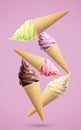 Delicious ice cream in crispy cones falling on pink background Royalty Free Stock Photo