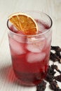 Delicious iced hibiscus tea and dry flowers on white wooden table, closeup Royalty Free Stock Photo