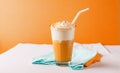 Delicious Iced latte or cappuccino in a glass on an orange background space for copy