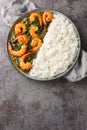 Delicious Indian prawn and spinach curry served with rice closeup on the plate. Vertical top view Royalty Free Stock Photo