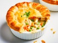 Delicious individual chicken creamy pot pie with vegetables in rich sauce with buttery flaky pastry. Cozy hearty meal