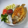 Delicious Indonesian fried fish served on white plates