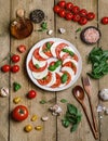 Delicious italian caprese salad with ripe tomatoes, fresh basil and mozzarella cheese on wooden rustic background. Italian caprese Royalty Free Stock Photo