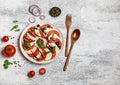 Delicious italian caprese salad with ripe tomatoes, fresh basil and mozzarella cheese on wooden rustic background. Italian caprese Royalty Free Stock Photo