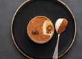 Delicious Italian dessert tiramisu, chocolate, cocoa and coffee beans on a black background. Top view with copy space. Royalty Free Stock Photo