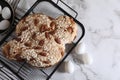 Delicious Italian Easter dove cake (Colomba di Pasqua) and decorative eggs on white marble table, flat lay