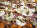 Delicious Italian pizza with ham and artichokes, cooked in the wood oven