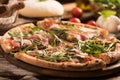 Italian Pizza with rocket salad on wooden table