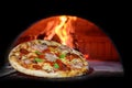 Delicious Italian pizza in a shovel putting in wood burning oven