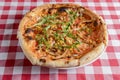 Delicious italian pizzas served on wooden table with red plaid table cloth Royalty Free Stock Photo