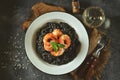 Delicious Italian risotto with grilled big tails of shrimp and cuttlefish ink squid-ink. Black risotto. Healthy tasty food.  Top Royalty Free Stock Photo