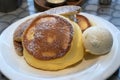 Delicious Japanese fluffy souffle pancake dessert with vanilla ice cream and caramelised bananas served on a white plate