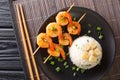 Delicious Japanese garlic fried rice served with shrimp kebabs close-up in a plate. horizontal top view Royalty Free Stock Photo