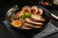 Delicious Japanese ramen noodle soup with pork, soft-boiled eggs, and garnishes