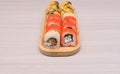 Delicious Japanese rolls with salmon, avocado, cucumber, cheese on wooden plate with selective focus. Asian food concept Royalty Free Stock Photo