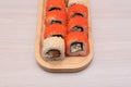Delicious Japanese rolls with salmon, avocado, cucumber, cheese on wooden plate with selective focus. Asian food concept Royalty Free Stock Photo