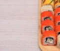 Delicious Japanese rolls with salmon, avocado, cucumber, cheese on wooden plate with selective focus. Asian food concept Royalty Free Stock Photo