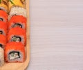 Delicious Japanese rolls with salmon, avocado, cucumber, cheese on wooden plate with selective focus. Asian food concept Royalty Free Stock Photo