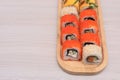 Delicious Japanese rolls with salmon, avocado, cucumber, cheese on wooden plate with selective focus. Asian food concept Royalty Free Stock Photo